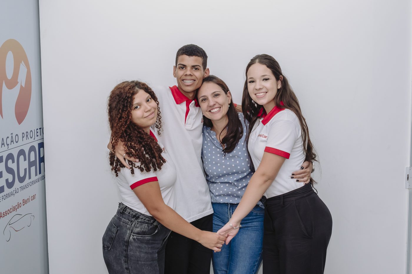 Quatro voluntários da Associação Beni Car sorrindo abraçados