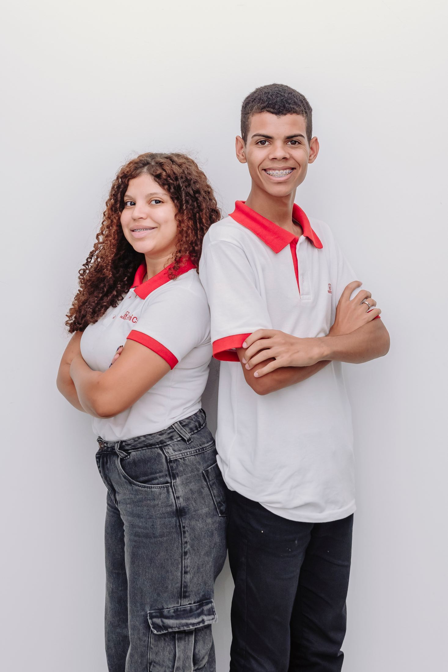 Dois alunos sorrindo, com uniforme de estágio